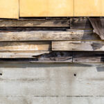 Asbestos,Siding,Falling,Apart,With,Exposed,Wood,And,Felt,Underneath.