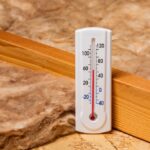 Fiberglass,Insulation,In,Attic,Of,House,With,Thermometer.,Home,Energy