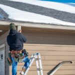 Contractor,Installing,Gutters,On,A,Residential,Building,In,The,Winter